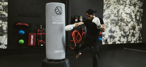 Man in white gloves punching custom freestanding bag