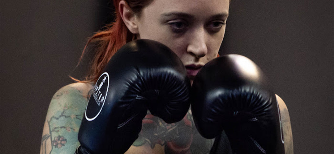 Woman with tattoos posing wearing black gloves