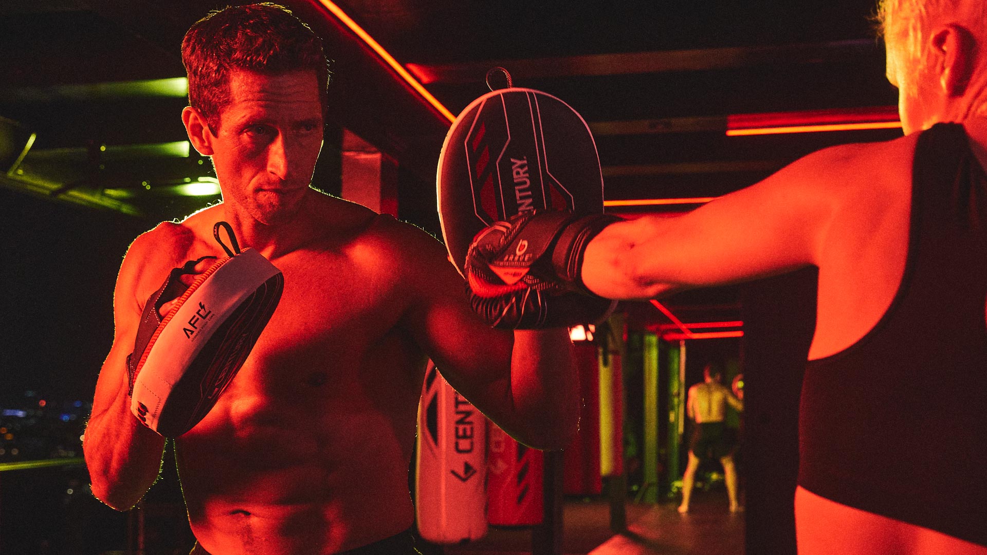two people sparring using brave boxing gloves and mitts