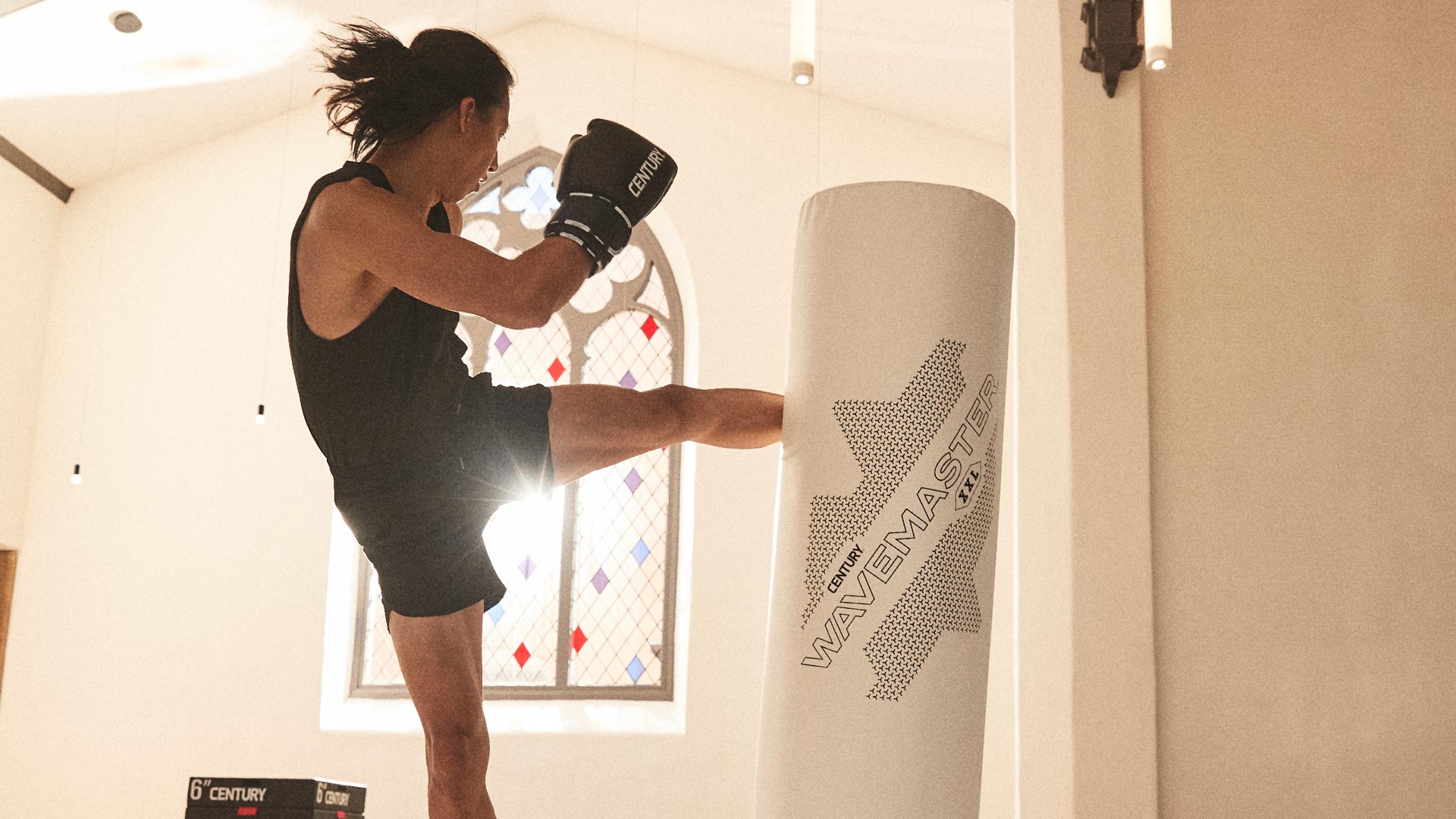 man kicking century's freestanding xxl wavemaster bag wearing gloves