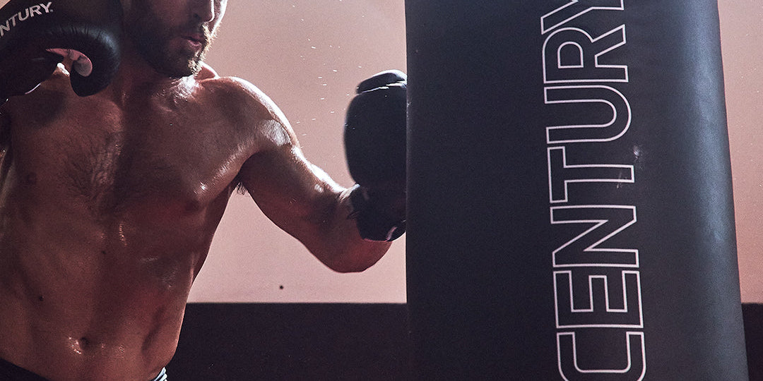 Man wearing gloves punching bag