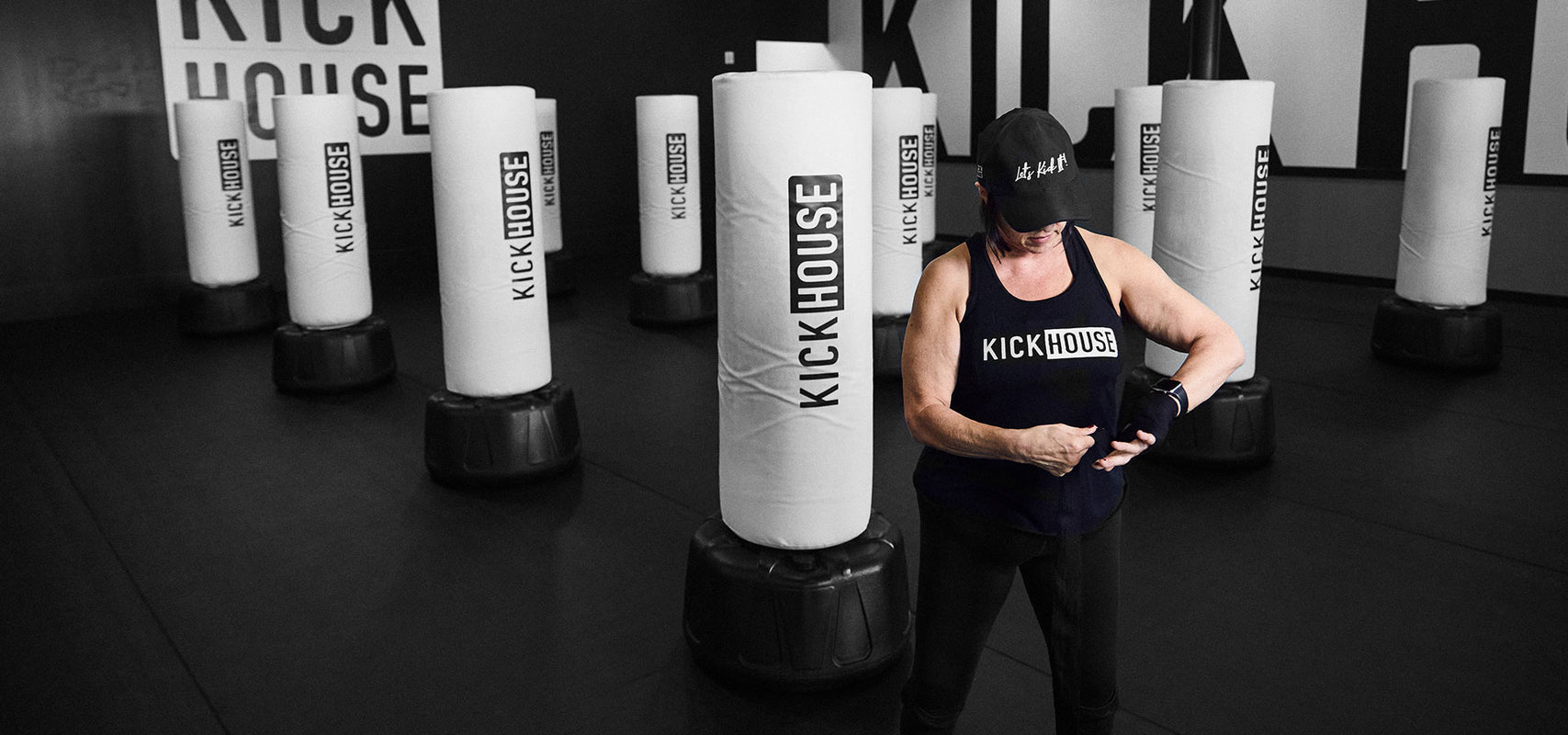 woman standing in front of punching bags